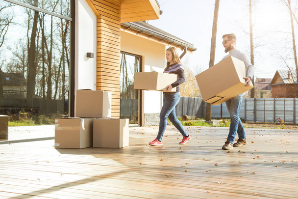 young couple moves to a new home. the family carries boxes of things after buying a home. - Photo, Image