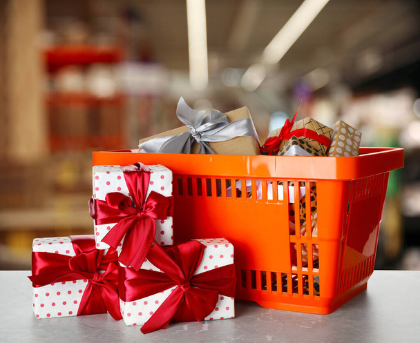 Süpermarketteki alışveriş sepeti hediye kutularıyla dolu. - Fotoğraf, Görsel