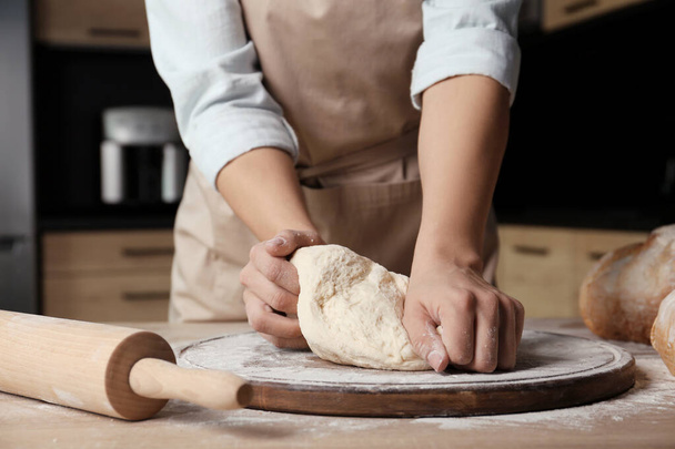 Female baker preparing bread dough at table, closeup - Фото, изображение