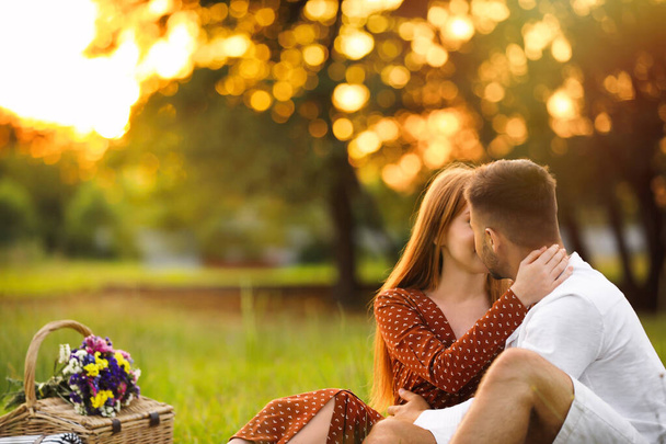 Happy young couple kissing in park. Picnic season - Fotó, kép