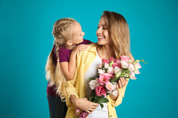 Little daughter congratulating her mom on blue background. Happy Mother's Day - Φωτογραφία, εικόνα
