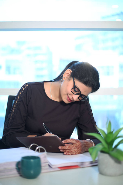 Νεαρή επιχειρηματίας που κάθεται στο γραφείο και εργάζεται χρησιμοποιώντας υπολογιστή, σύγχρονη εκτελεστική κοπέλα στο γραφείο. - Φωτογραφία, εικόνα