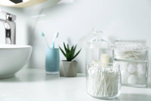 Jar with cotton swabs on white countertop in bathroom - Foto, Imagem