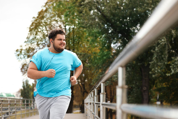 Young overweight man running outdoors. Fitness lifestyle - Φωτογραφία, εικόνα