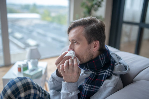 Bearded man holding napkin while having stuffy nose - Photo, image