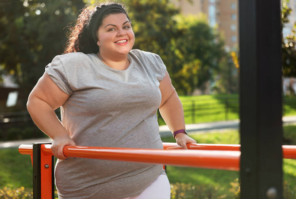 Beautiful overweight woman training on sports ground - Foto, afbeelding
