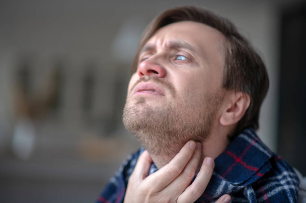 Niebieskooki mężczyzna z okropnym bólem szyi - Zdjęcie, obraz