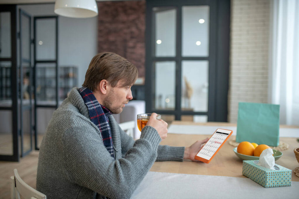 Businessman updating schedule on tablet after falling sick - Zdjęcie, obraz