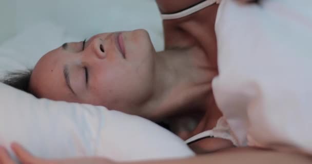 Csinos fiatal felnőtt nő alszik a hotel hálószobájában - Felvétel, videó