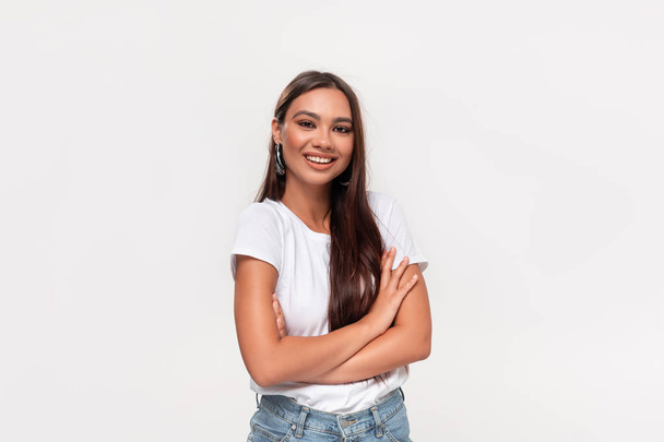 Pretty african-american teenager in a white tee and blue jeans smiling standing isolated over white background. - Photo, Image