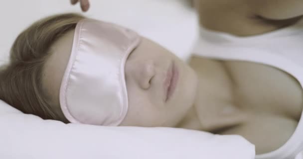 Csinos fiatal felnőtt nő alszik hotel hálószobában szemfedővel - Felvétel, videó