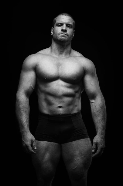 sportowiec stojący na czarnym tle, uprawiający sport - Zdjęcie, obraz