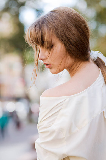 Gorgeous girl wears white blouse walks in the park - Photo, image