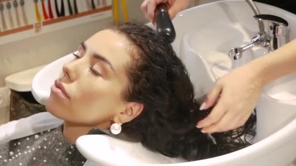 Fryzjer myje kobiece włosy - Materiał filmowy, wideo