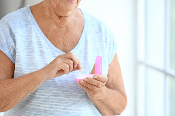 Elderly woman taking medicine at home, closeup - Foto, Bild