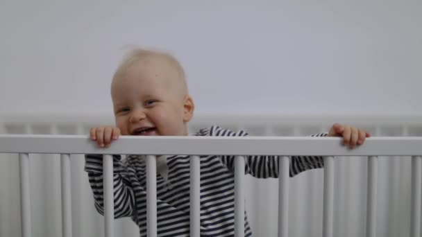 schattig glimlachen baby jongen spelen in bedje - Video