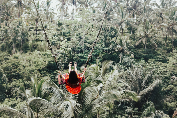 Молодая красивая азиатка качается на скале в джунглях
  - Фото, изображение