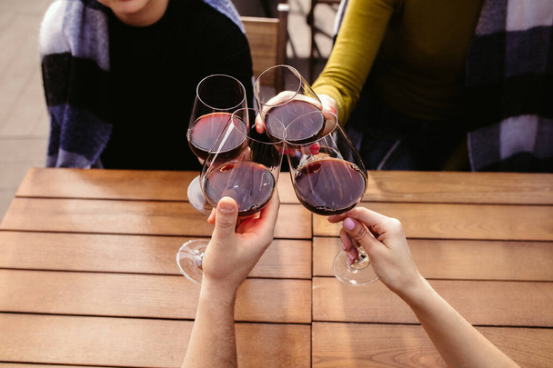 People clinking glasses with wine on the summer terrace of cafe or restaurant. Close up shot, lifestyle. - Fotoğraf, Görsel
