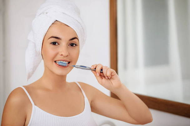 Beautiful young woman brushing teeth - Photo, image