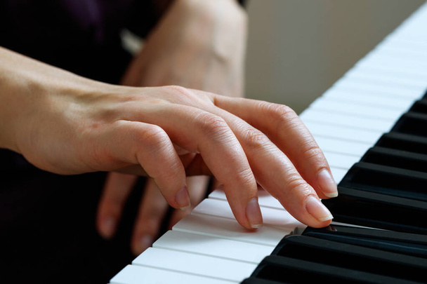 jonge vrouw spelen piano - Foto, afbeelding