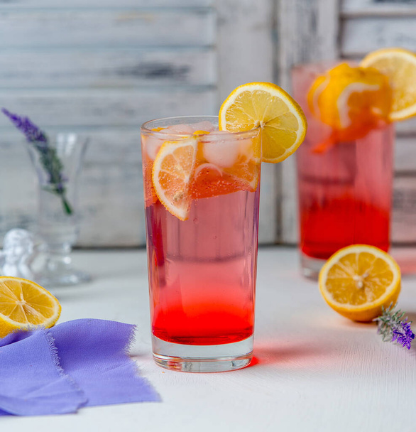 red juice with lemon slices and ice cubes in glass - Foto, imagen