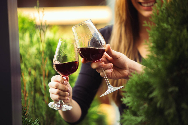 Mensen klappen glazen met wijn op het zomerterras van café of restaurant. close-up shot, levensstijl. - Foto, afbeelding