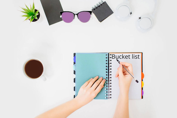 Flatlay with female hands writing bucket list. - Photo, Image