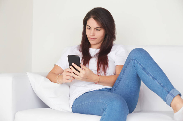 woman talking to mobile on the sofa - Photo, image