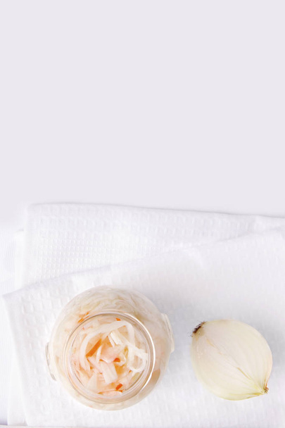 Ζυμωμένο λάχανο σε ένα βάζο, δίπλα στο κρεμμύδι. Λευκό φόντο. Αντιγραφή χώρου - Φωτογραφία, εικόνα