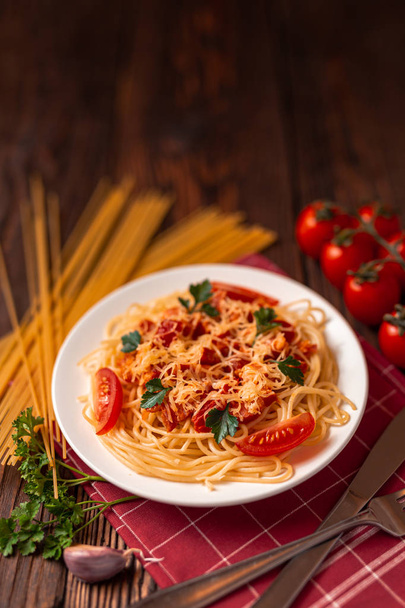 Pasta carbonara with tomato sauce and minced meat, grated parmesan cheese and fresh parsley - homemade healthy italian pasta on rustic wooden background.  - 写真・画像