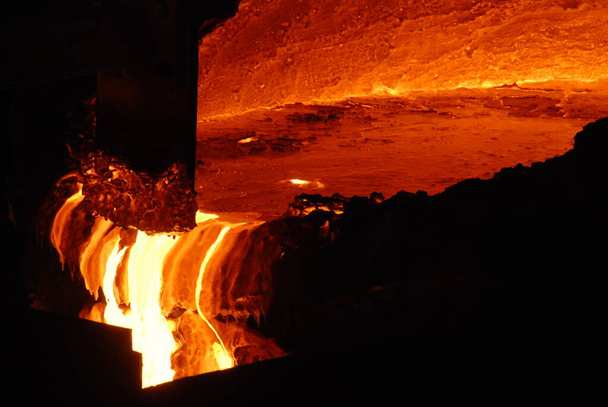 Erittäin harvinainen tiivis näkymä avoimen tulisija uunin metallurgisen tehtaan. Sulaa kuumaa terästä
 - Valokuva, kuva