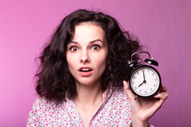 beautiful curly girl in pajamas, pink background - 写真・画像