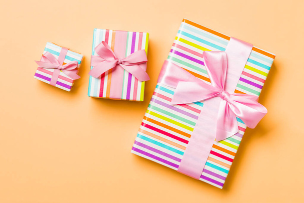 Top vista regalo di Natale scatola con fiocco rosa su sfondo arancione
 - Foto, immagini