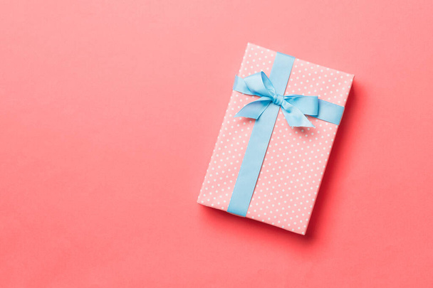 Top pohled vánoční dárek box s modrým lukem na živé korálové pozadí s kopírovacím prostorem - Fotografie, Obrázek