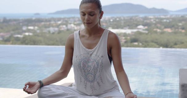 Erwachsene Dame praktiziert Yoga, während sie sich im Resort ausruht - Foto, Bild