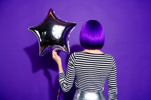 Back rear side photo of charming lady holding star-shaped baloon isolated over purple violet background - 写真・画像