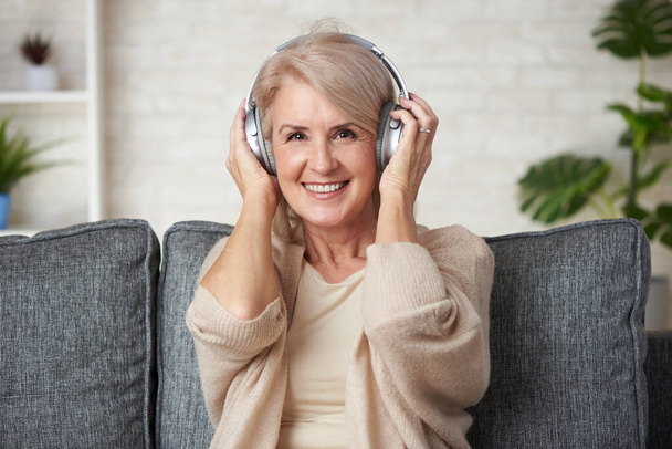 Happy senior woman is listening to music - Fotoğraf, Görsel