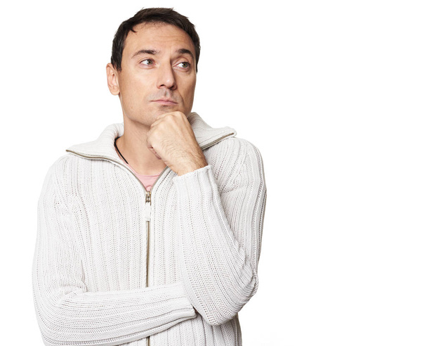 Mladý pohledný muž nosí svetr s rukou na bradě myšlení - Fotografie, Obrázek