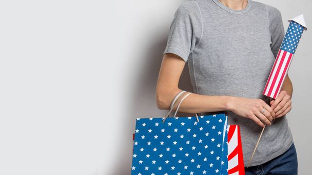 Beautiful woman with shopping bags and a firework rocket over white background - Foto, immagini