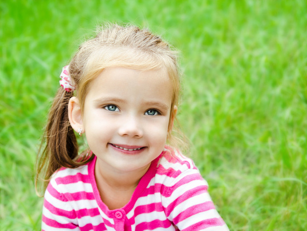Portrait of cute smiling little girl on the meadow - Fotoğraf, Görsel