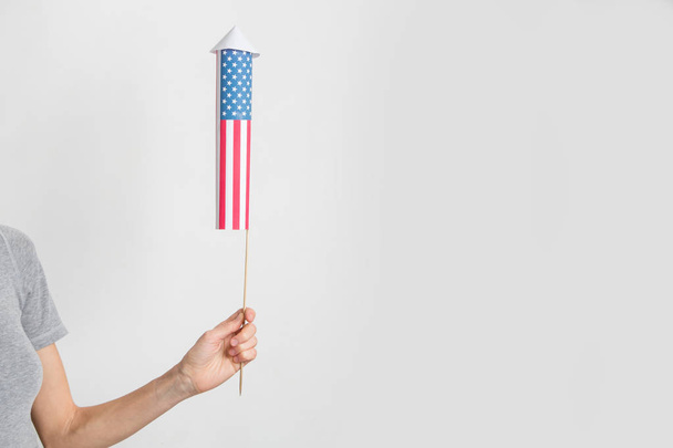 Female hand with a firework rocket over white background. 4 th of July, independence day concept - Foto, imagen