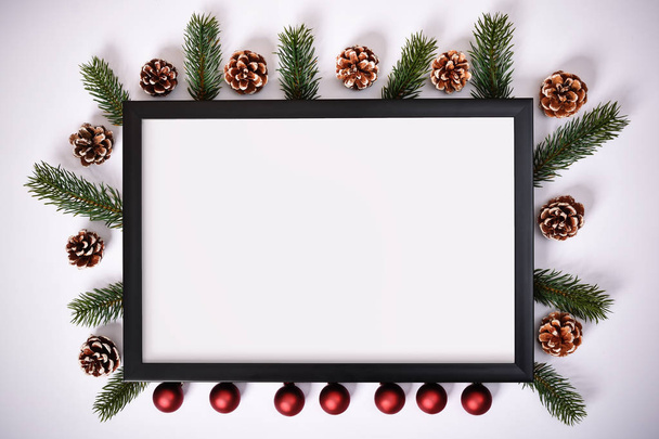 Christmas and New Year composition. Photo frame, pine cones, evergreen branches and decoration on white background. Christmas, winter, new year concept. Flat lay, top view, copy space, square. - Φωτογραφία, εικόνα