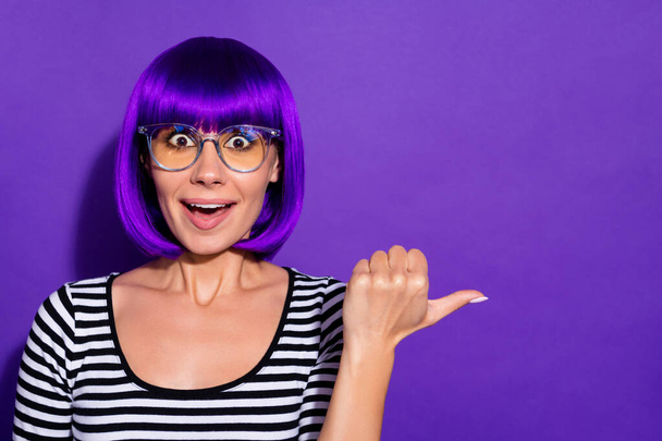 Photo of crazy lady indicating finger empty space with open mouth wear wig striped pullover isolated purple background - Foto, Imagem