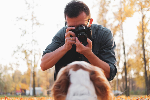 Man taking a photo of his dog in the park.  - Zdjęcie, obraz
