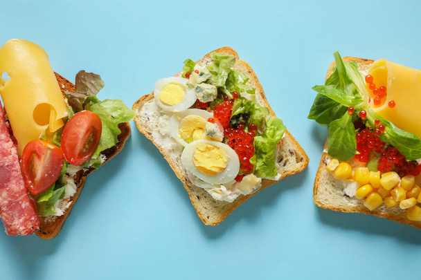Вкусные бутерброды на цветном фоне - Фото, изображение