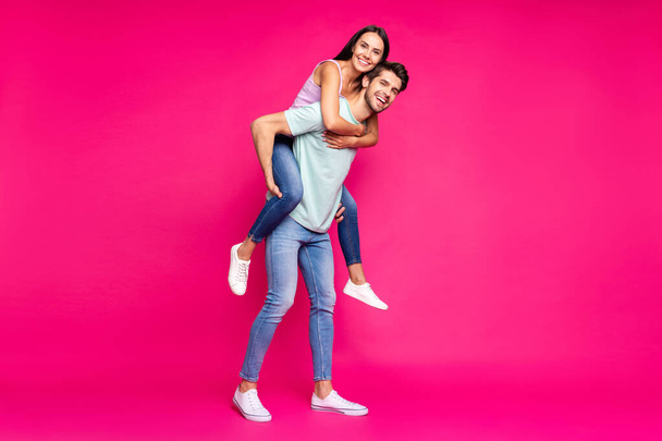 Full length photo of funny guy and lady holding piggyback spending best free time wear casual clothes isolated vibrant vivid pink color background - Foto, immagini
