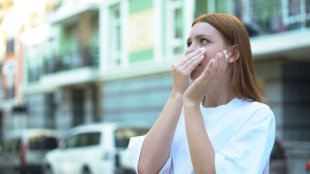 Girl closing nose with hand, unpleasant harmful smell in area, air pollution - 写真・画像