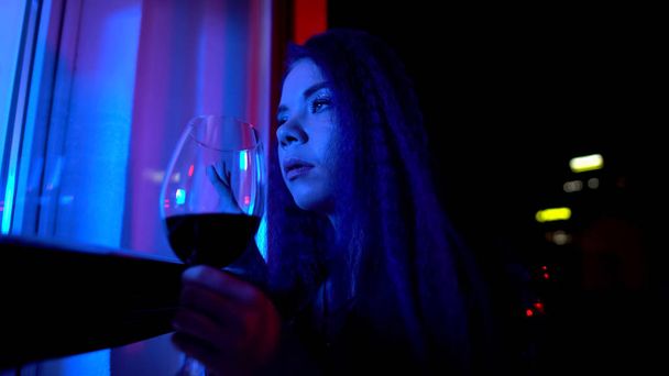 Party girl holding wine glass, spying after unfaithful boyfriend through window - Foto, Imagem