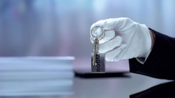 Hotel administrator holding keychain with word room written on it, HoReCA - Foto, Bild