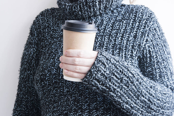 Mujer sosteniendo taza de café caliente en la pared blanca, de cerca foto de
 - Foto, imagen